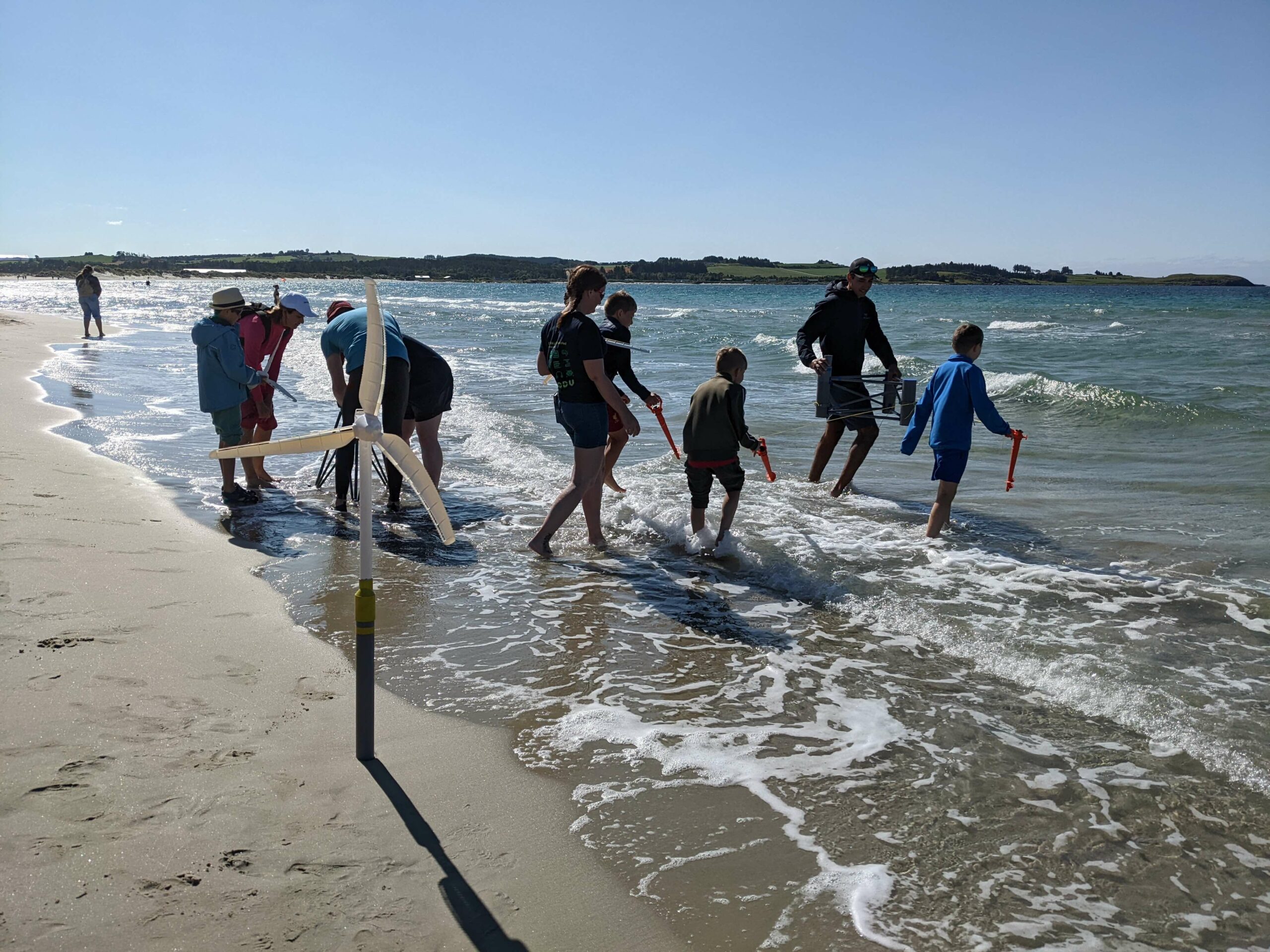 Children and miniature wind mill at beach